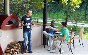 Great Outdoor Pizza Ovens friends gathered around red Alfa Allegro outdoor wood-fired pizza oven