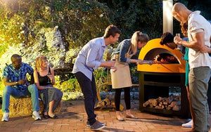 Great Outdoor Pizza Ovens friends gathered around yellow Alfa Allegro outdoor wood-fired pizza oven
